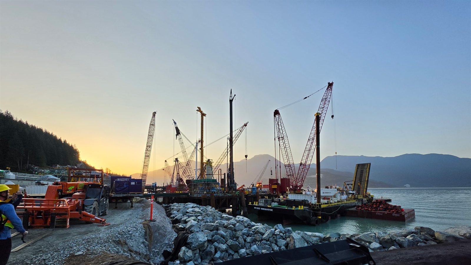 Marine construction barges and crane spread at the Woodfibre LNG site on Howe Sound at sunrise